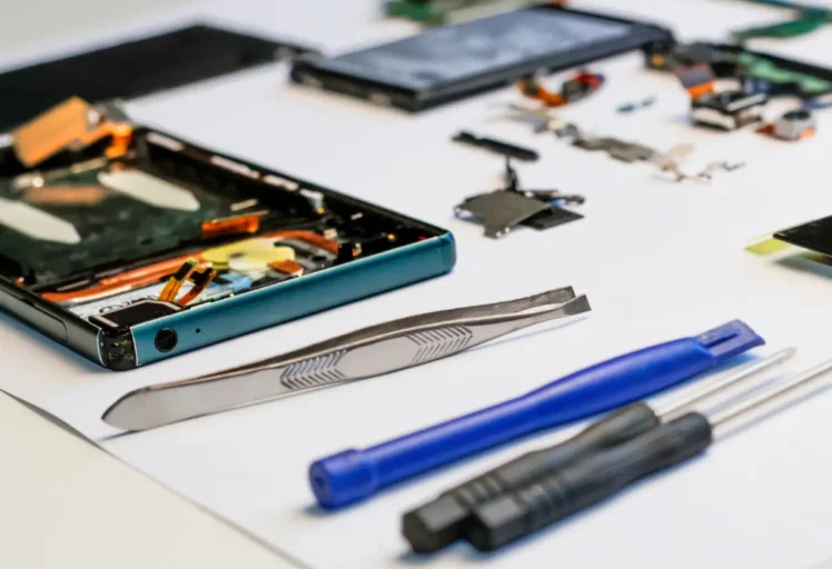 Téléphone démonté pour réparation, entourée des outils